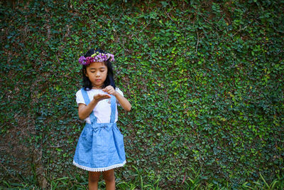 Portrait of girl standing against plants