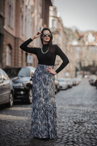 Portrait of young woman standing in city