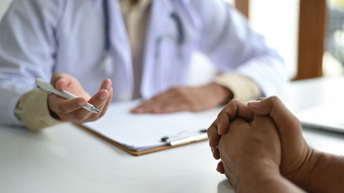 Midsection of couple holding hands on table