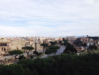 View of cityscape against cloudy sky