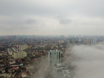 Foggy morning in the city buildings growing through the mist and fog