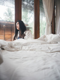 Young woman relaxing on bed at home