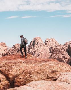 Man on rock against sky