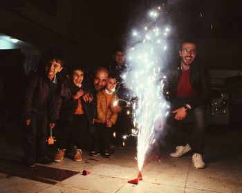 People enjoying firework display on walkway at night