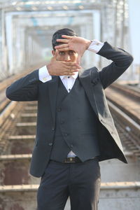 Midsection of man holding smart phone while standing outdoors