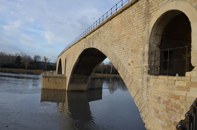 Arch bridge over river against sky