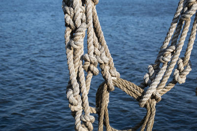 Close-up of rope hanging against sea