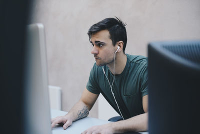 Computer programmer using desktop pc in office