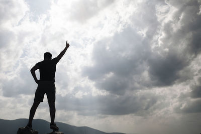 Low angle view of silhouette man standing against sky