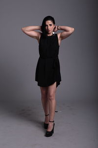 Portrait of young woman standing against white background