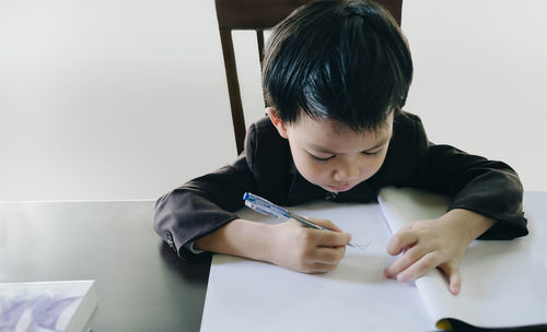 Rear view of a boy holding paper