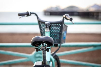 Close-up of bicycle on railing by river
