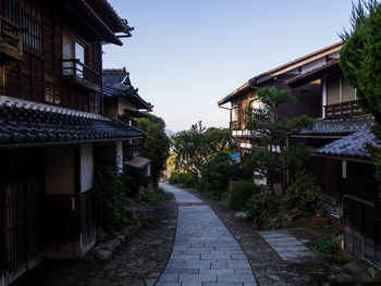 Footpath amidst houses and buildings against sky