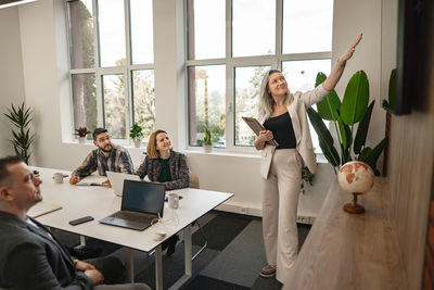 Portrait of woman using digital tablet while sitting on table