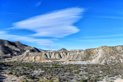 Scenic view of rocky mountains against blue sky