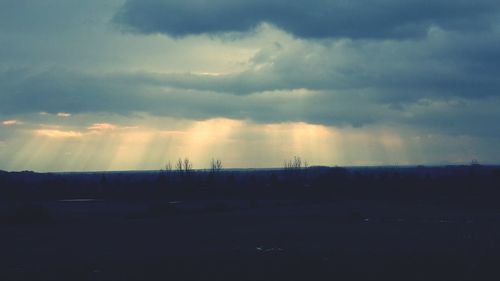 Scenic view of field against cloudy sky