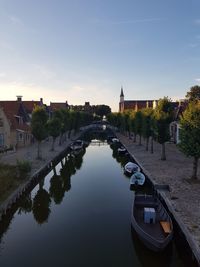 Canal amidst buildings against sky in city