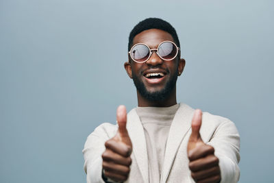 Portrait of woman wearing sunglasses against blue background