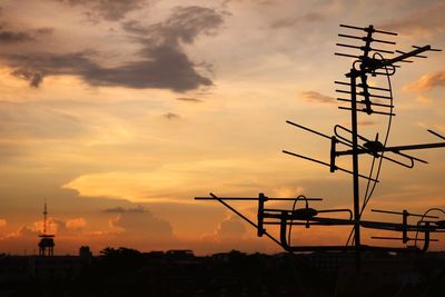 Silhouette of television aerial against sky during sunset