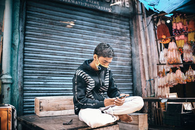 Man looking at camera while sitting on shutter