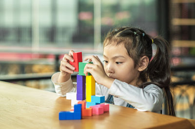 Portrait of girl with toy on table