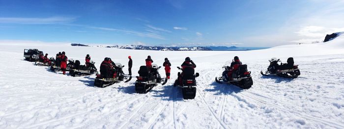 Rear view of people on snowmobiles