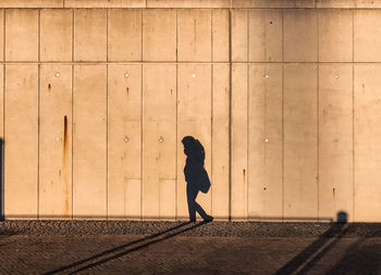 Side view of a woman standing against blurred background