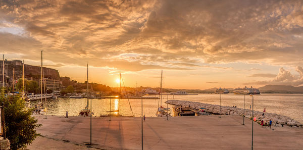 Sailboats in sea against sky during sunset