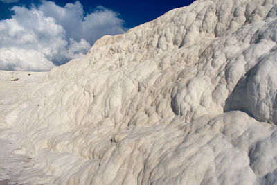 Low angle view of snow on landscape against sky