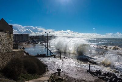 Water splashing in sea against sky