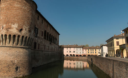Buildings in city against clear sky
