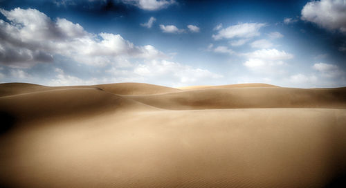 Sand dunes in desert against sky