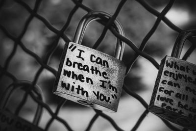 Close-up of text on chainlink fence