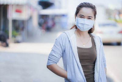 Portrait of beautiful young woman standing on street in city