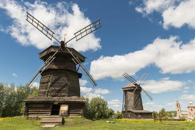 Traditional windmill on field against sky