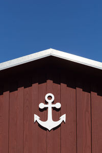 Low angle view of building  with an anchor against blue sky