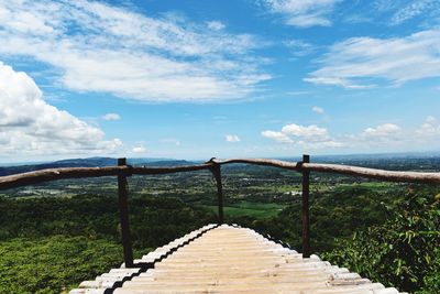 Footbridge over river against sky