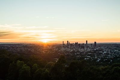 Scenic view of city against sky during sunset