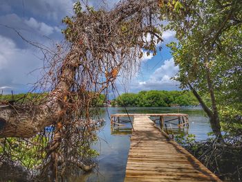 Wooden pier over lake against sky