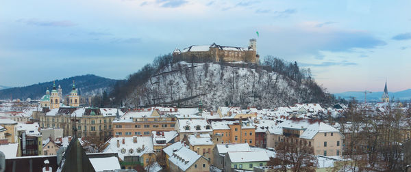 Buildings in town against sky during winter