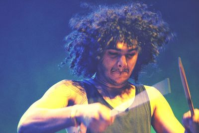 Close-up of man holding drumstick at concert