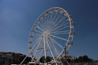 Low angle view of ferris wheel against blue sky