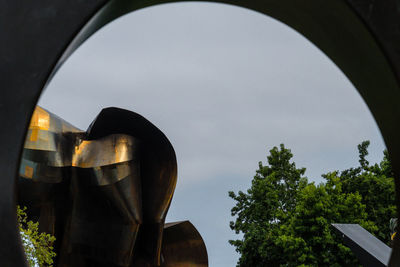 Low angle view of building seen through hole