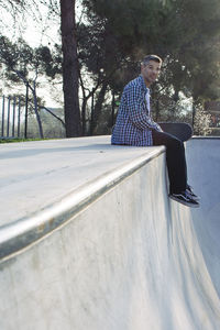 Portrait of man sitting on ramp in park