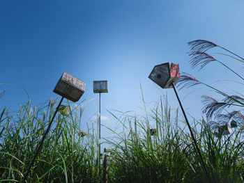 Low angle view of birdhouse on field against clear sky