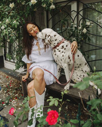 Portrait of young woman with dog on field