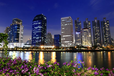 Illuminated city buildings against sky at night