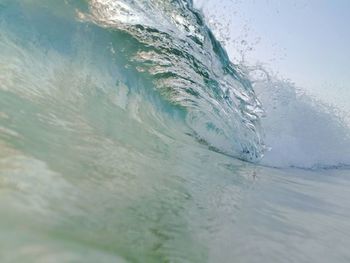 Close-up of water splashing in sea against sky
