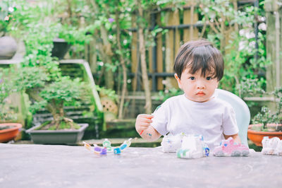 Portrait of cute boy sitting outdoors