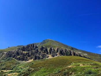 Scenic view of mountain against blue sky